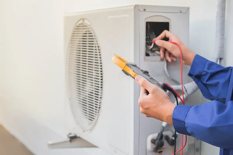 AC technician fixing split unit at home in Jeddah – Ali Cooling Center